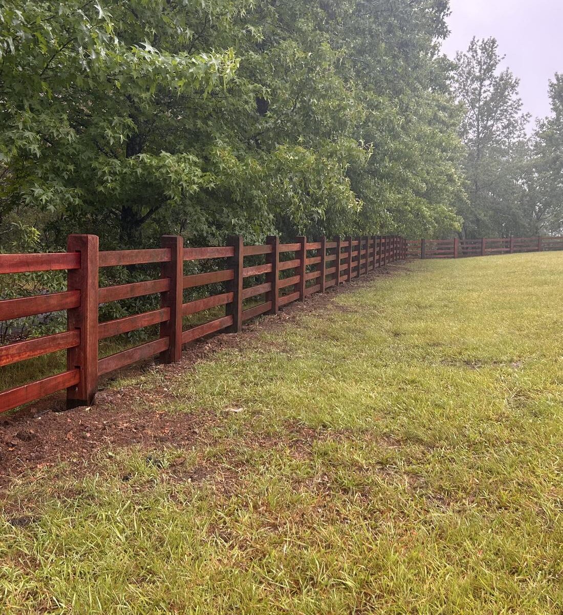 Post and rail fence line running toward distant hills