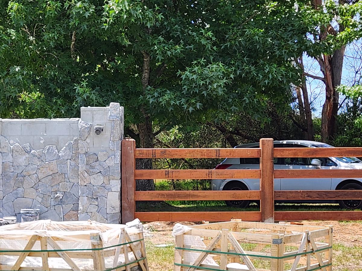 Hardwood post and rail fence meeting a stone wall