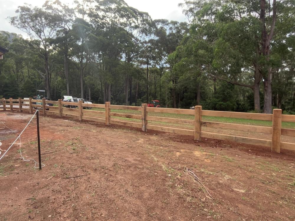 Three rail grey box fence around a new rural build