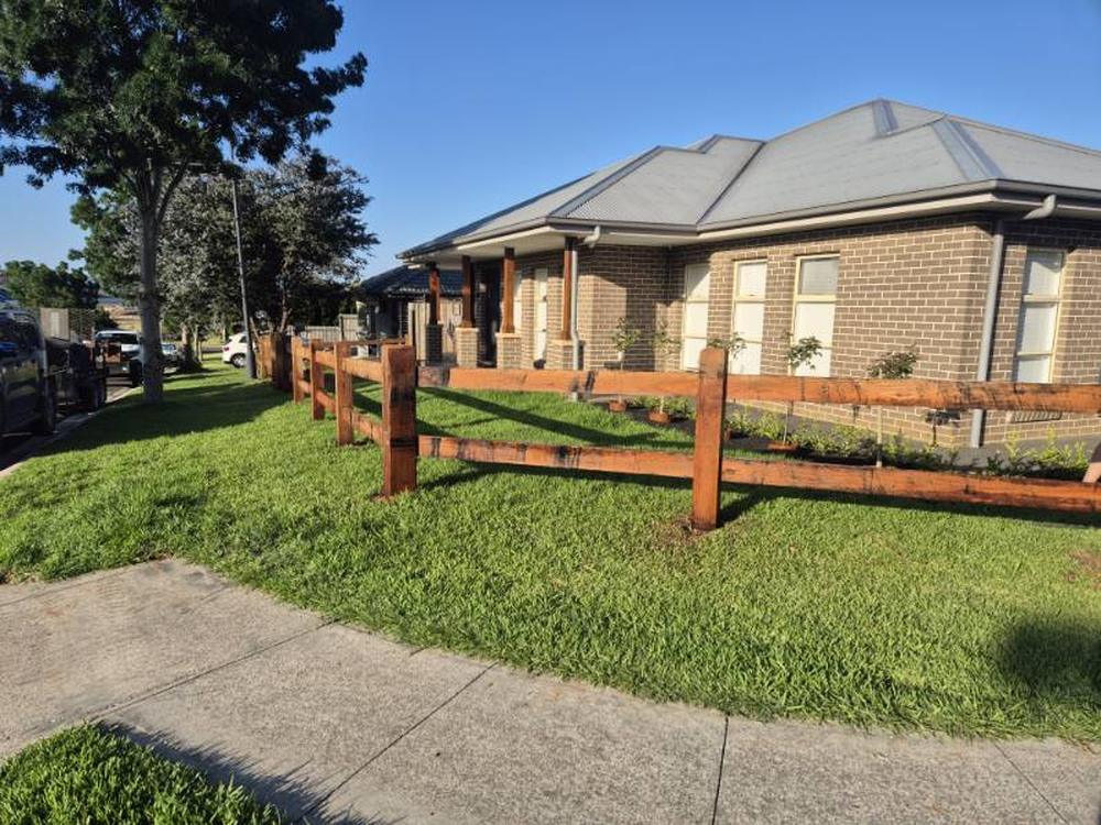 Two rail hardwood fence along a street frontage